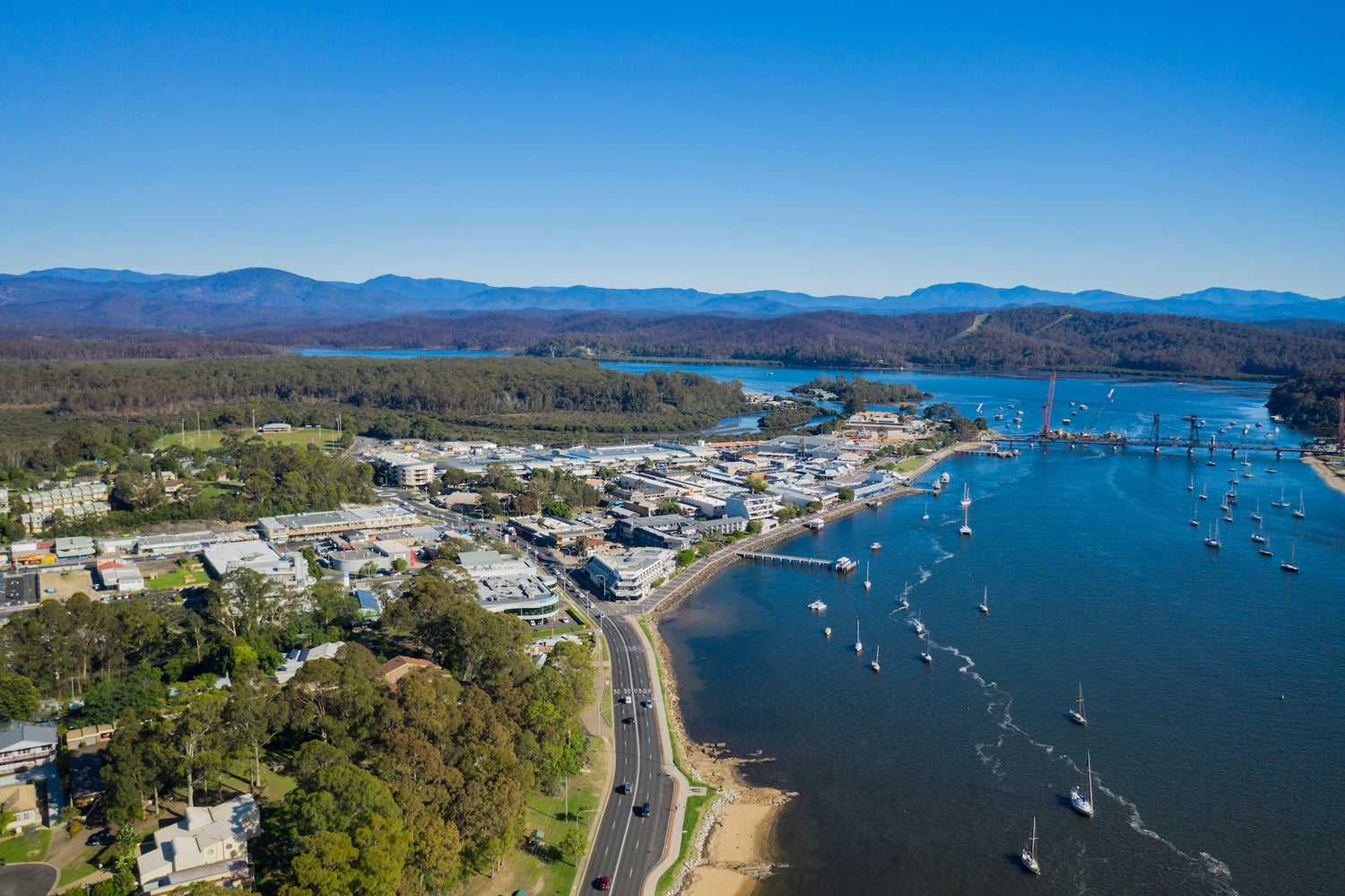 Aerial view of Batemans Bay and the Clyde River with mountains in the background.