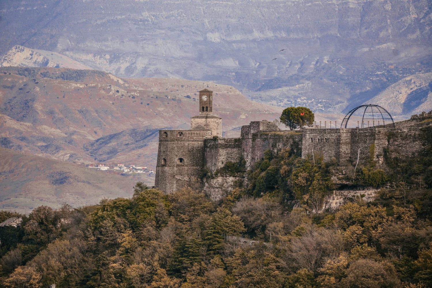 Old castle on a hill in Albania with mountains in the background.