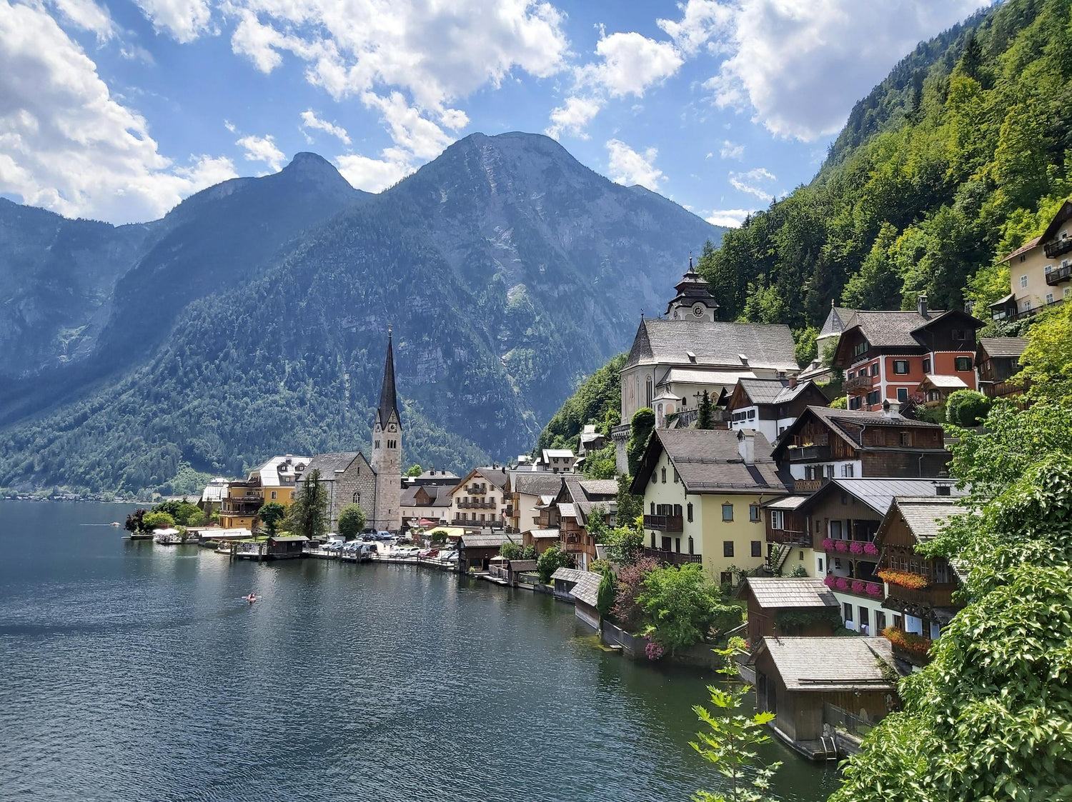 Scenic view of Hallstatt featuring a village by a lake with mountains in the background