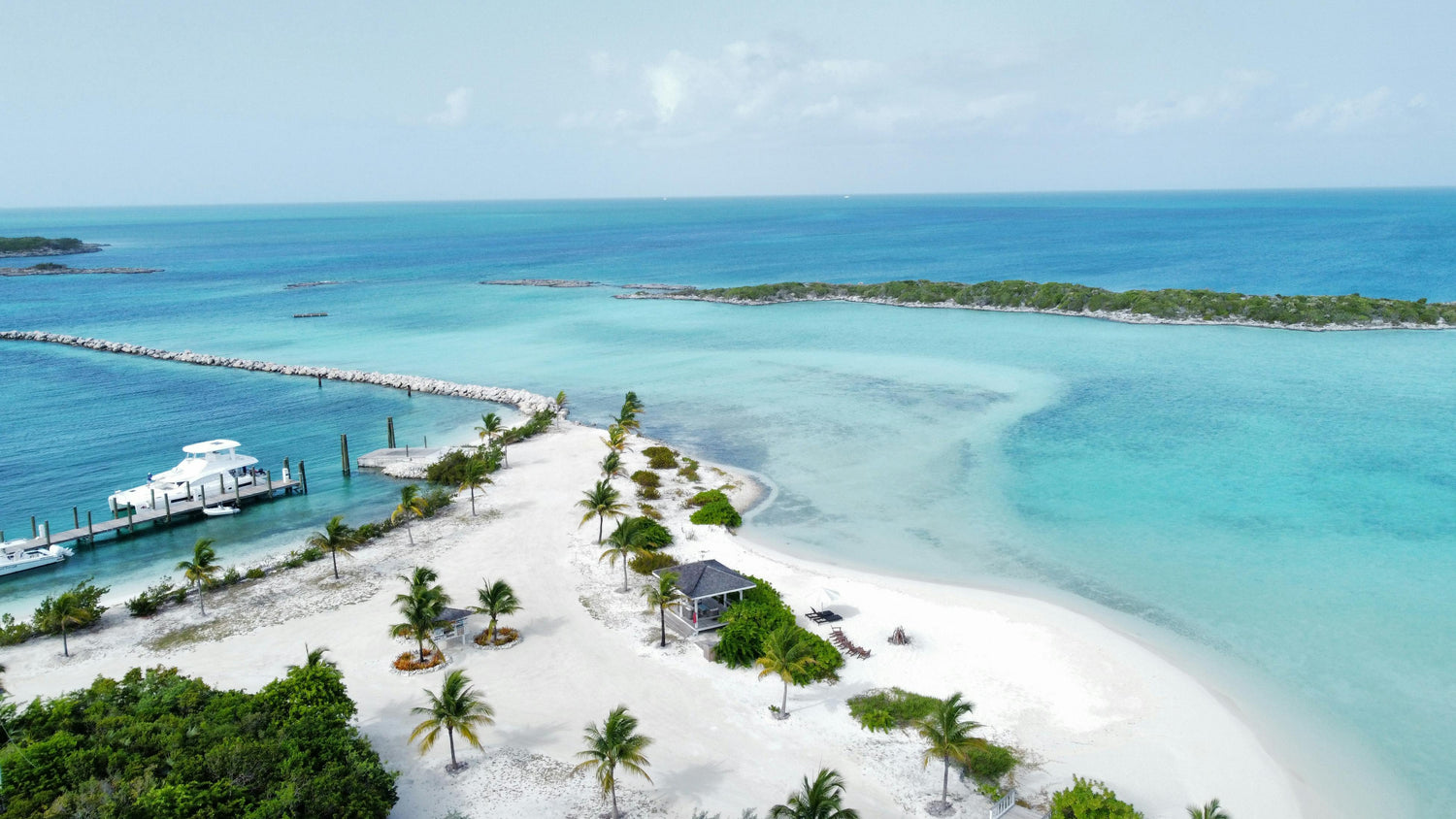 Beach in the Bahamas with a pier and clear blue water