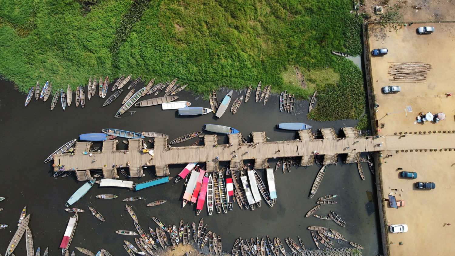 Aerial view of a dock in Benin with numerous boats moored along a riverbank.