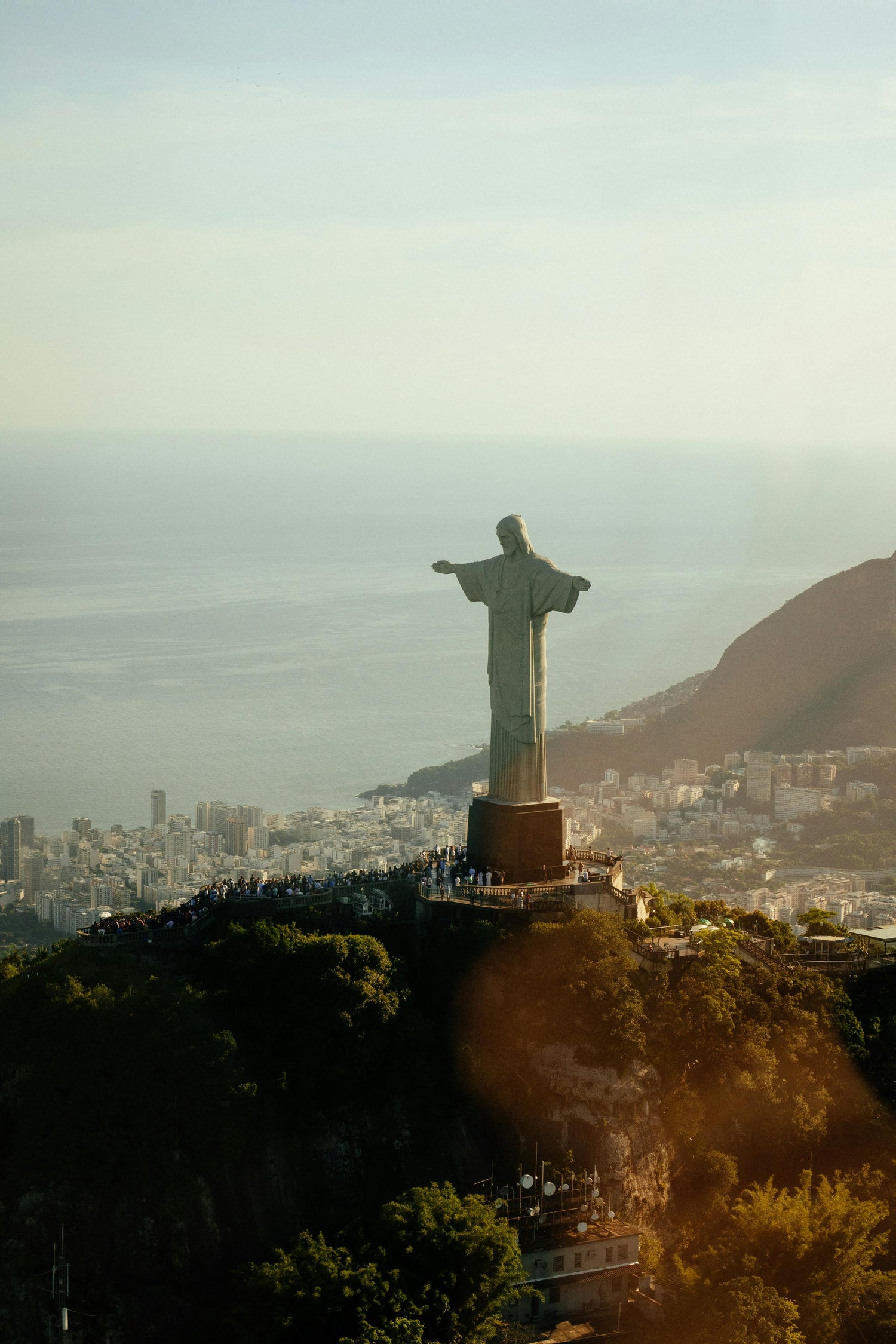 Statue of Christ the Redeemer overlooking a cityscape with mountains in the background
