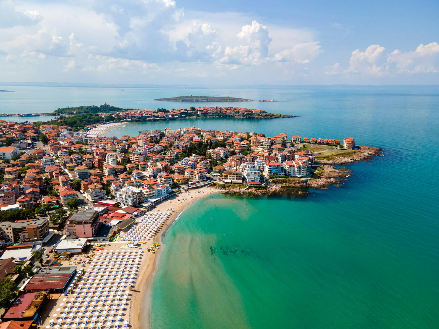 Aerial view of a coastal town in Bulgaria with a beach and turquoise water.