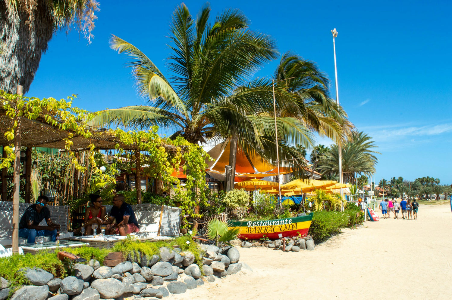 Beachside restaurant in Cabo Verde with palm trees and a clear blue sky
