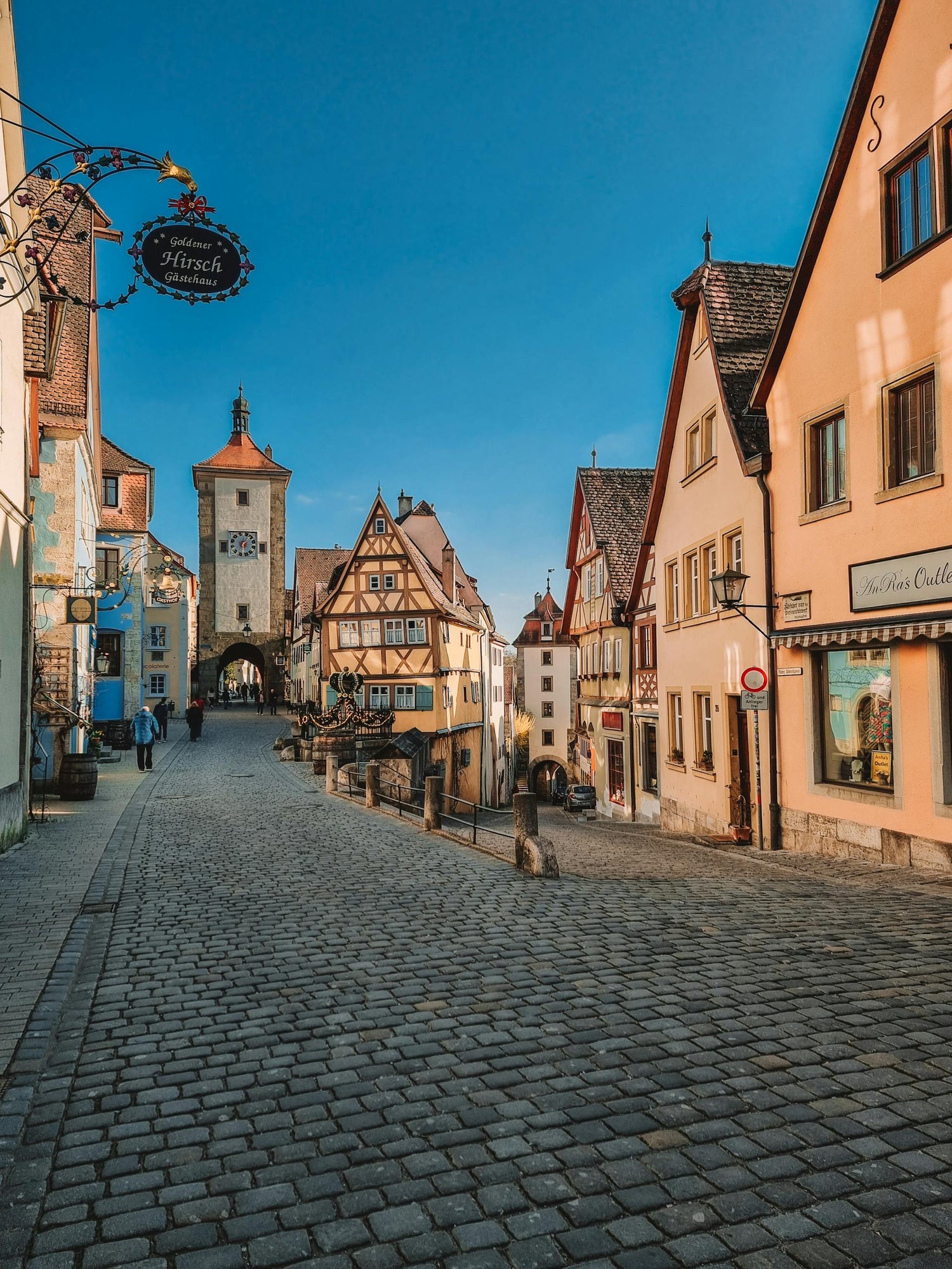 Cobbled street in a Germany with historic buildings under a clear blue sky.
