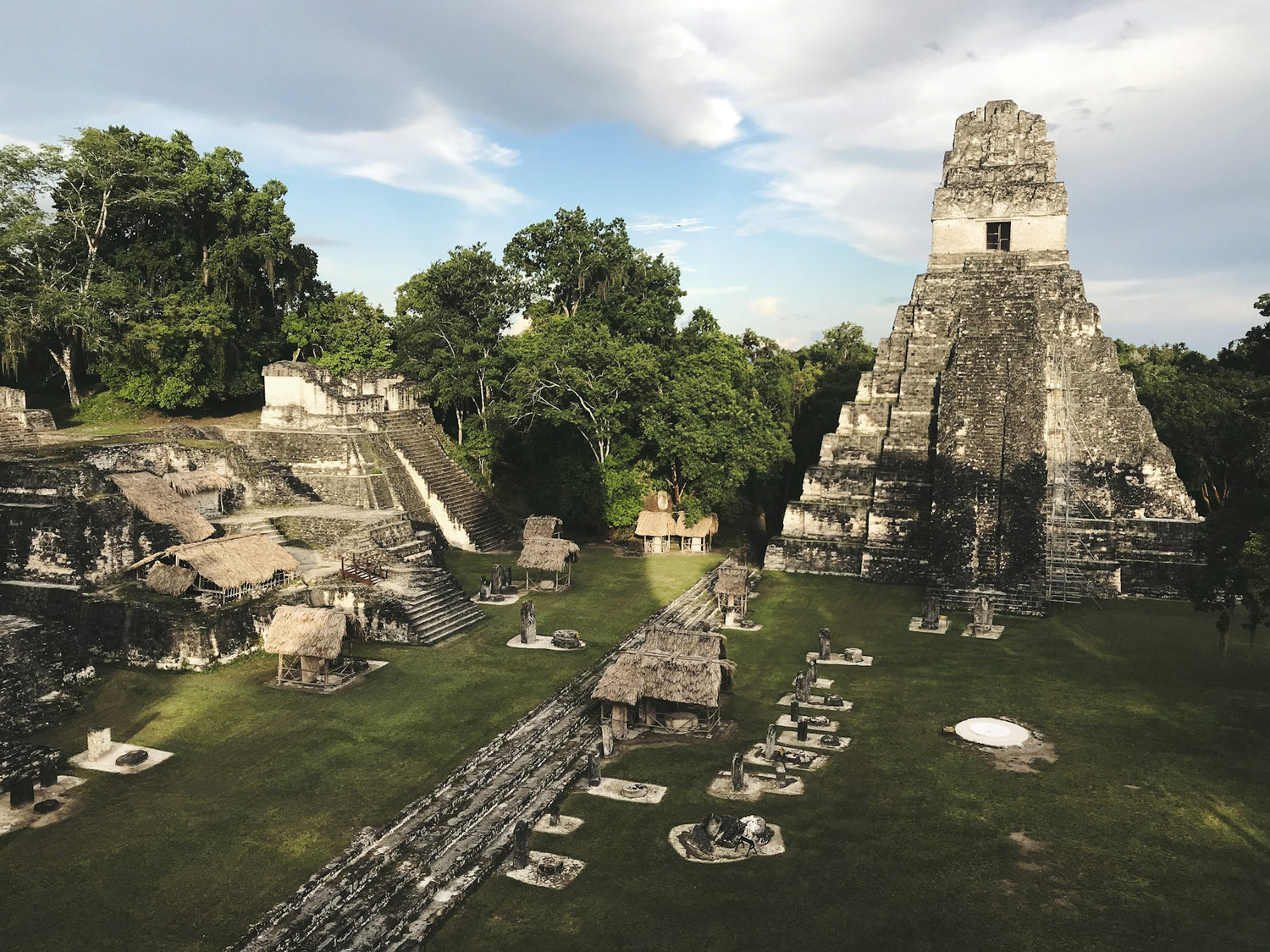 Mayan pyramid in Tikal National Park in Guatemala with greenery and a clear sky.