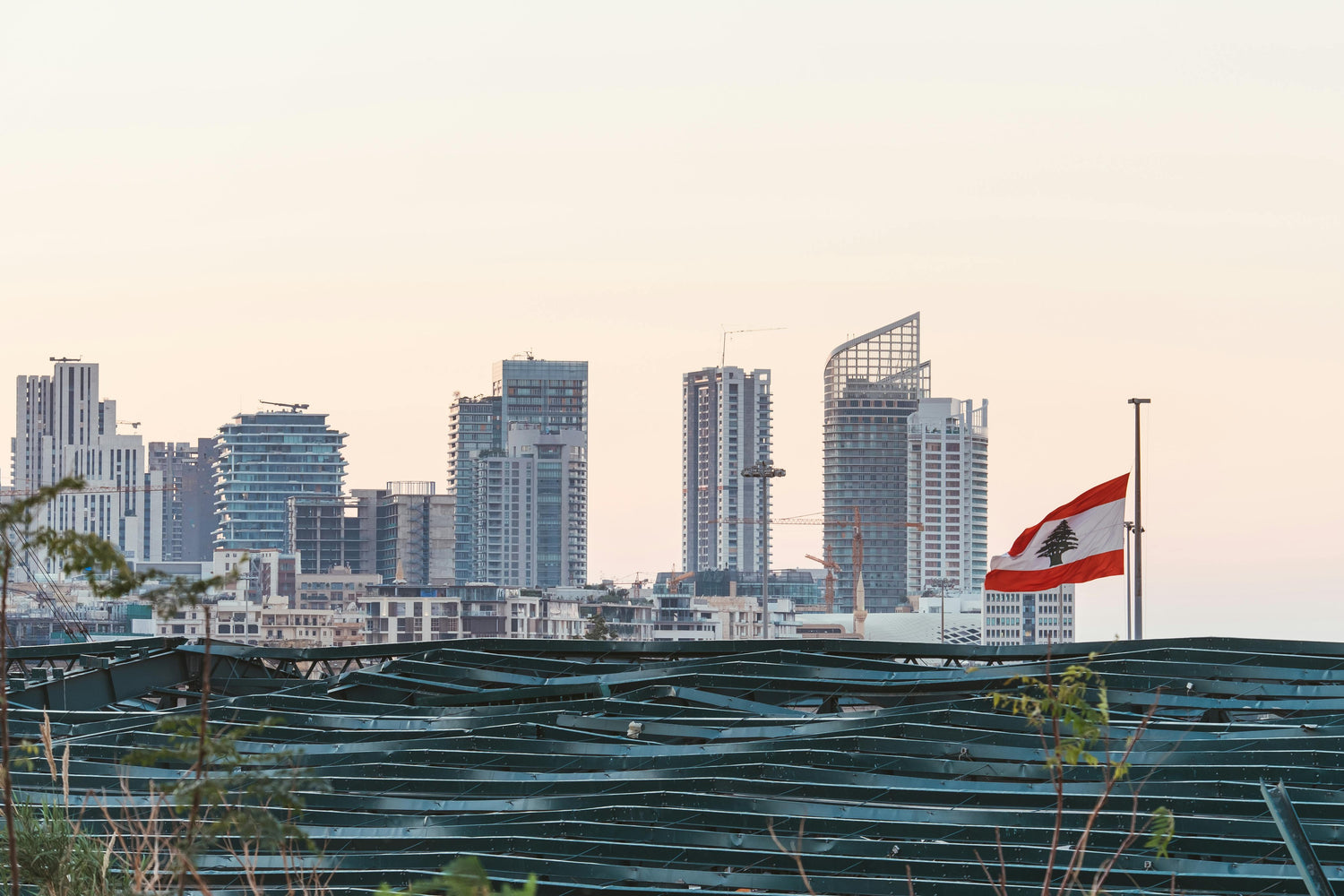 City skyline of Lebanon with modern buildings and a flag in the foreground.
