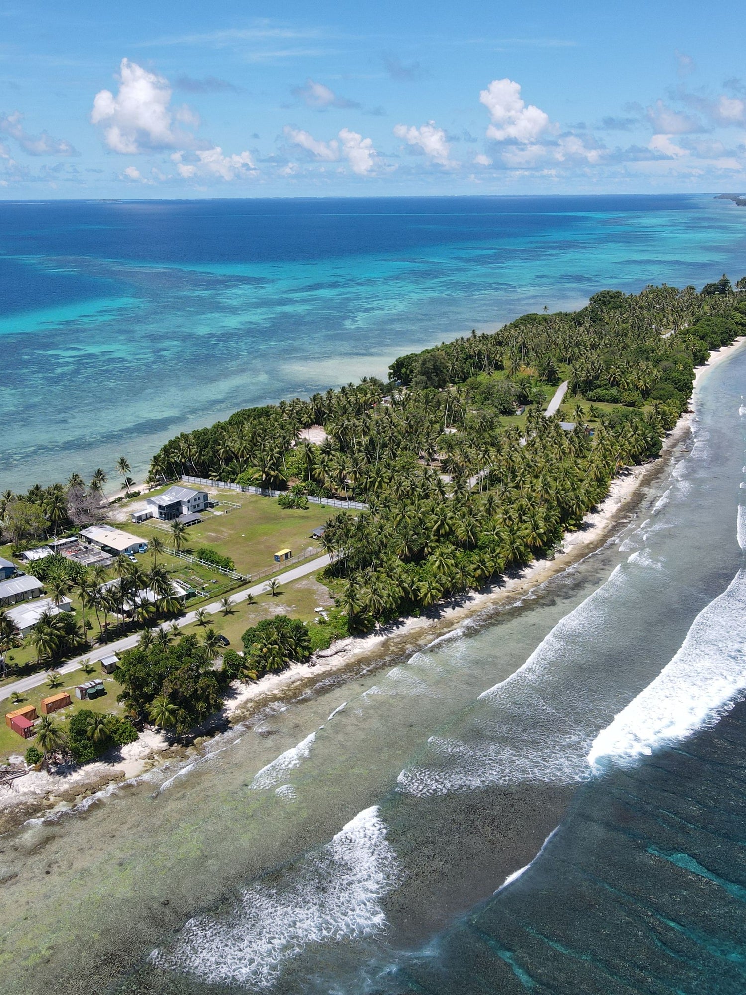 Aerial view of the Marshall Islands with lush greenery and a clear blue ocean.