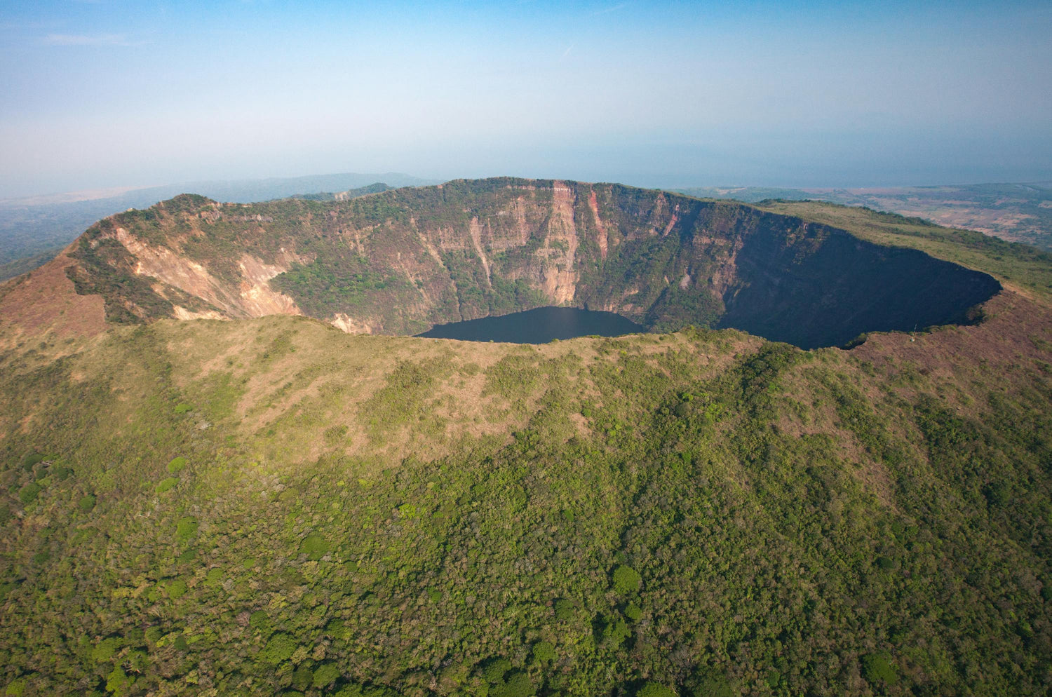 Aerial view of a large crater with greenery on a clear day, Chinandega in Nicaragua.