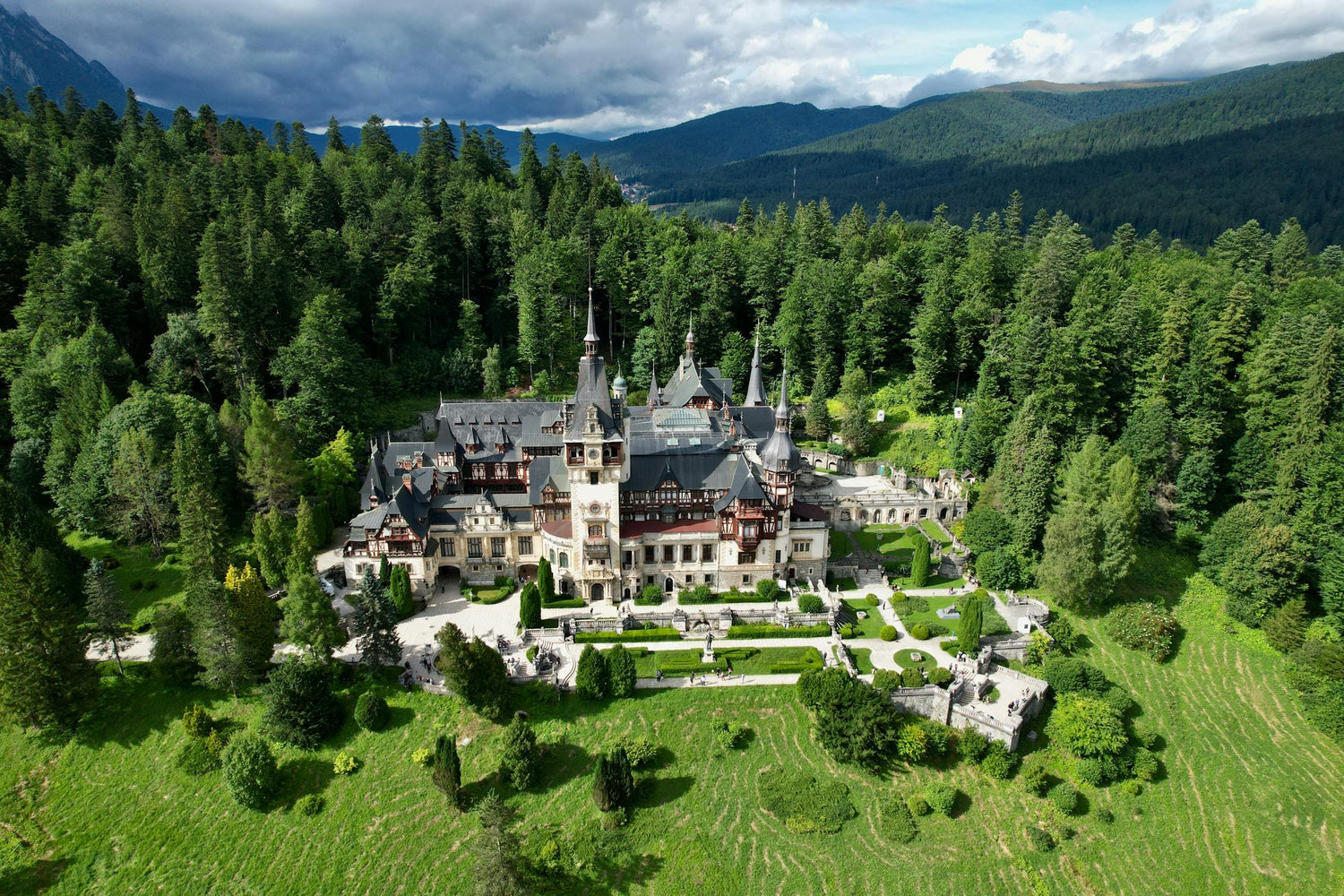 Castle in Romania surrounded by lush greenery and mountains