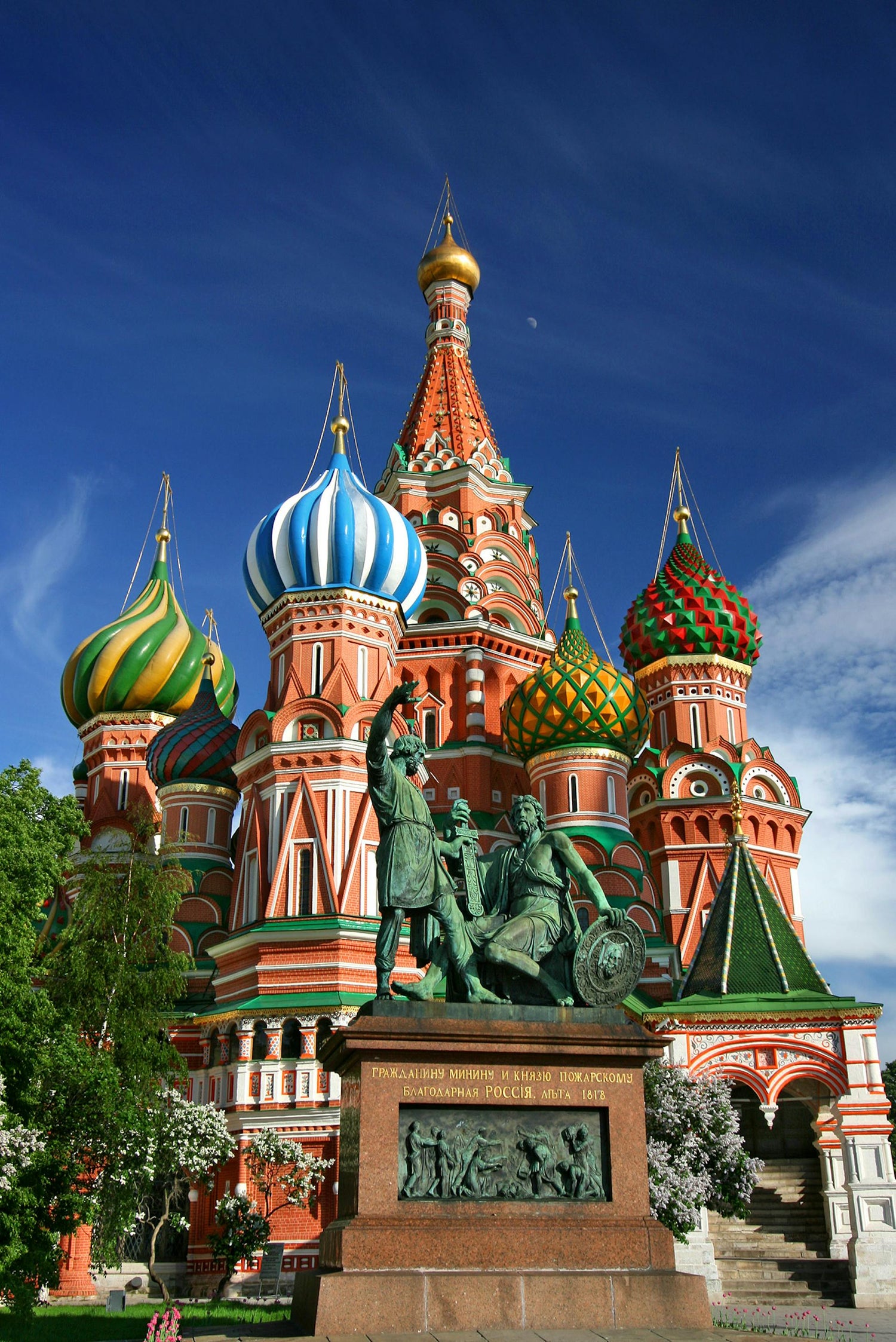 St. Basil's Cathedral with a statue in front, with a blue sky and clouds in the background