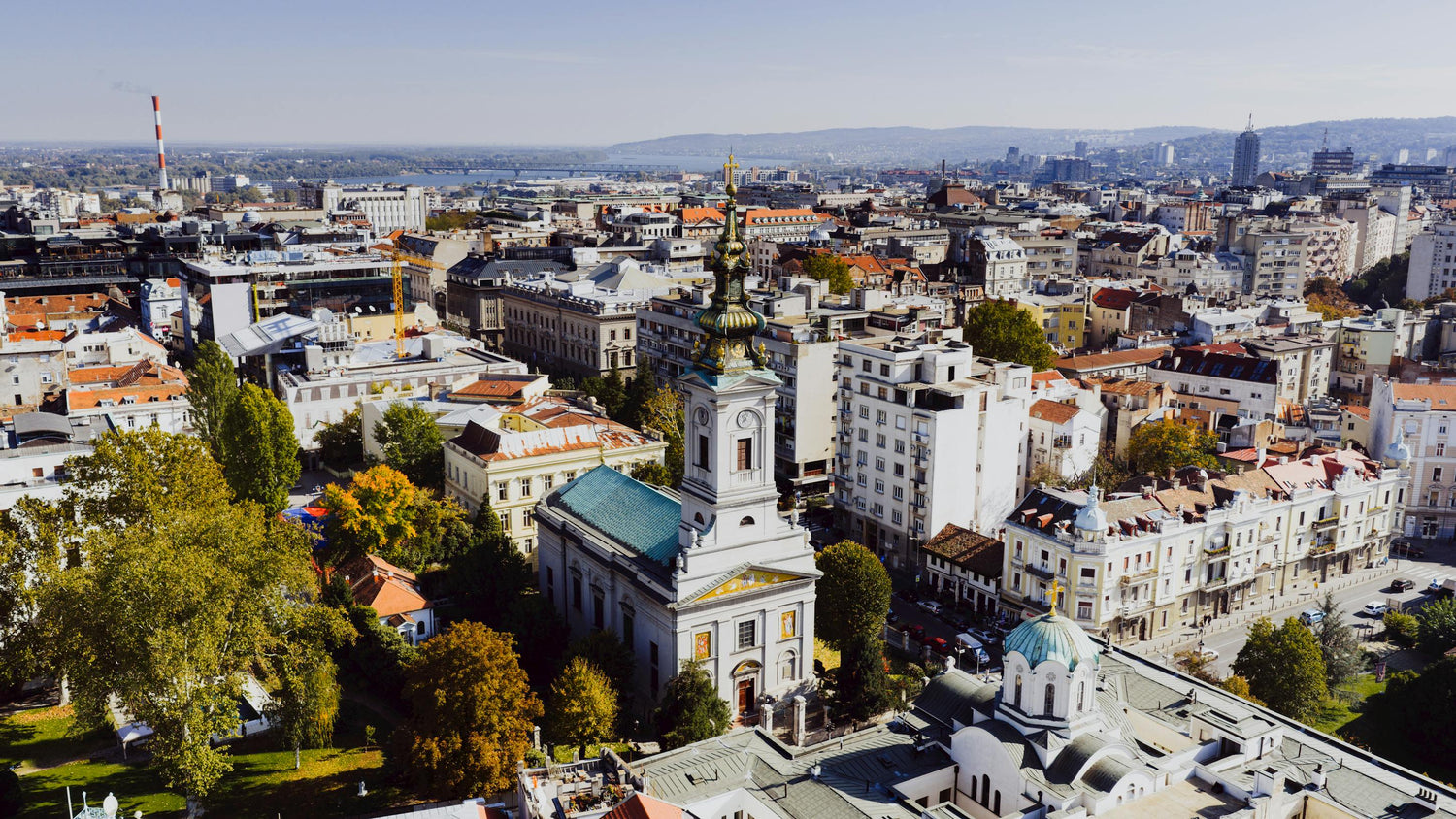 Aerial view of a cityscape in Serbia with a prominent church building.