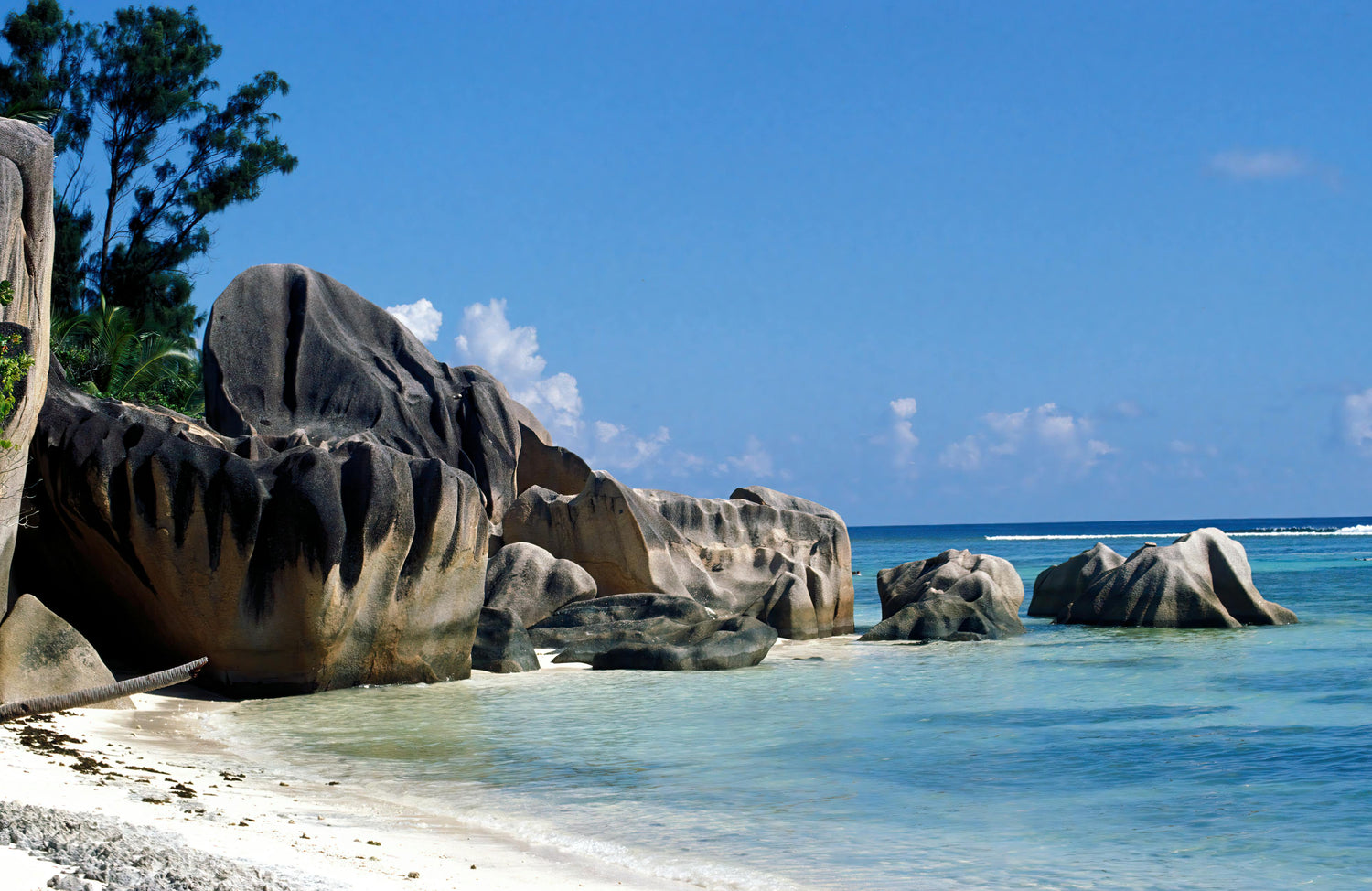 Beach in Seychelles with large rock formations and clear blue water