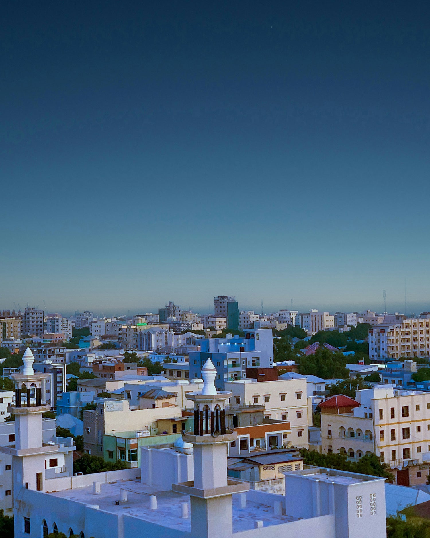 Picture of a city in Somalia featuring ornate roof decorations with a blue sky in the background.