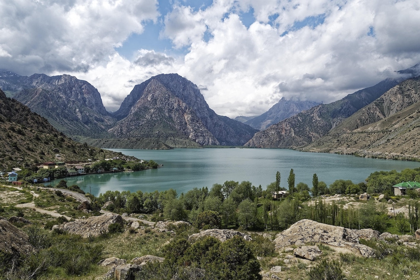 Lake in Tajikistan surrounded by mountains under a cloudy sky