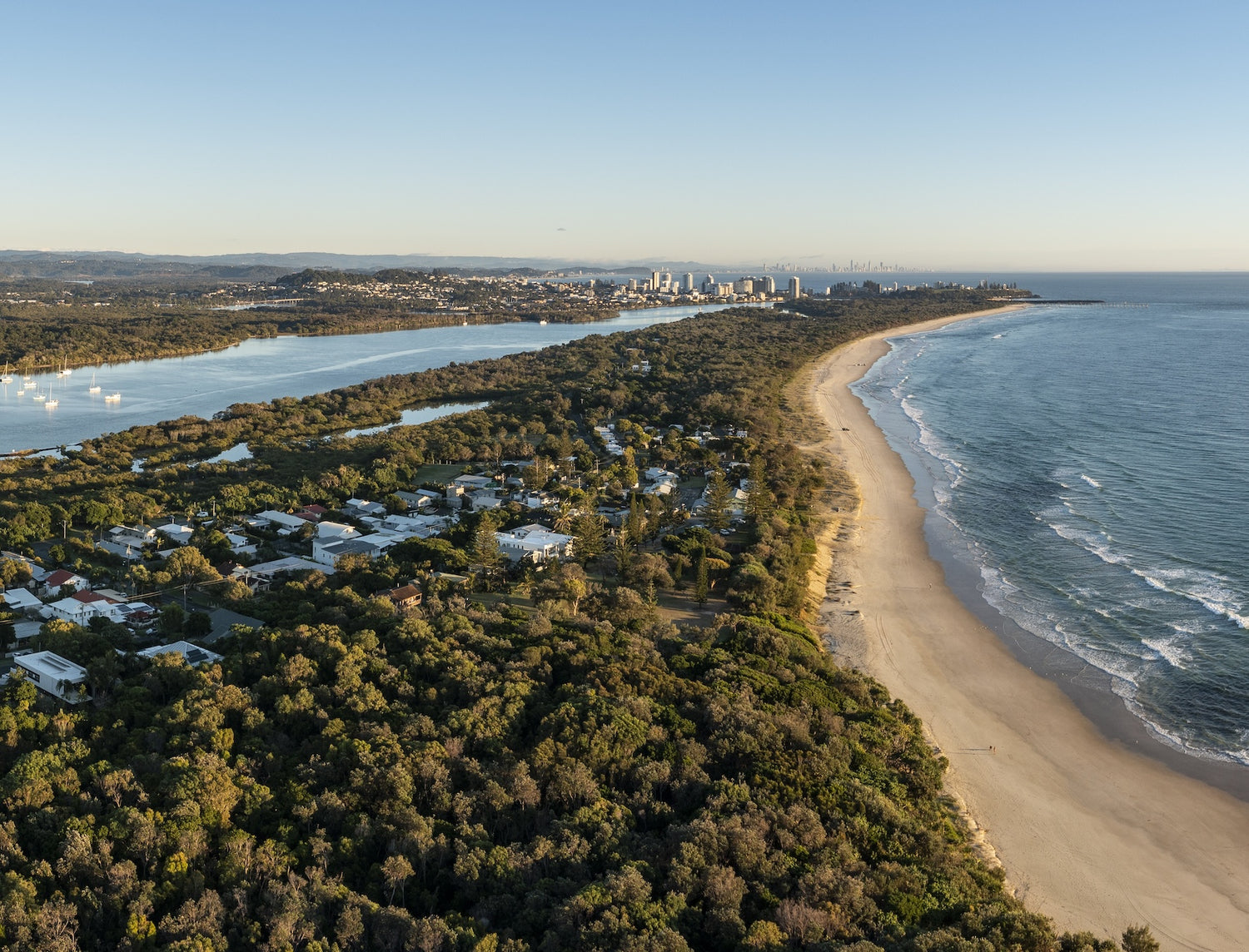 Aerial view of Tweed Heads with Kingscliff Beach, forest, and city skyline.