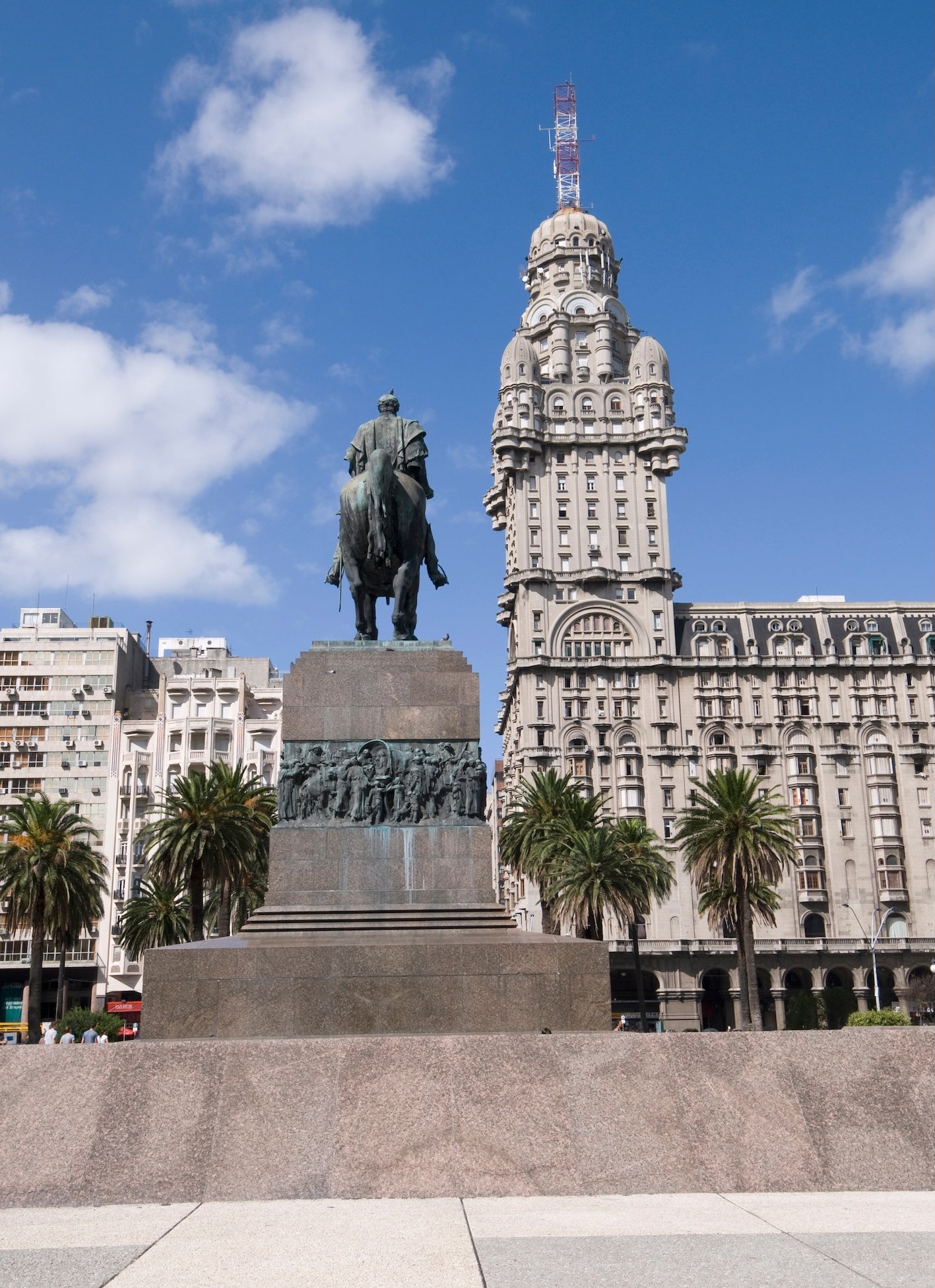 Statues, palm trees and Palacio Salvo, in Plaza Independencia, Montevideo, Uruguay